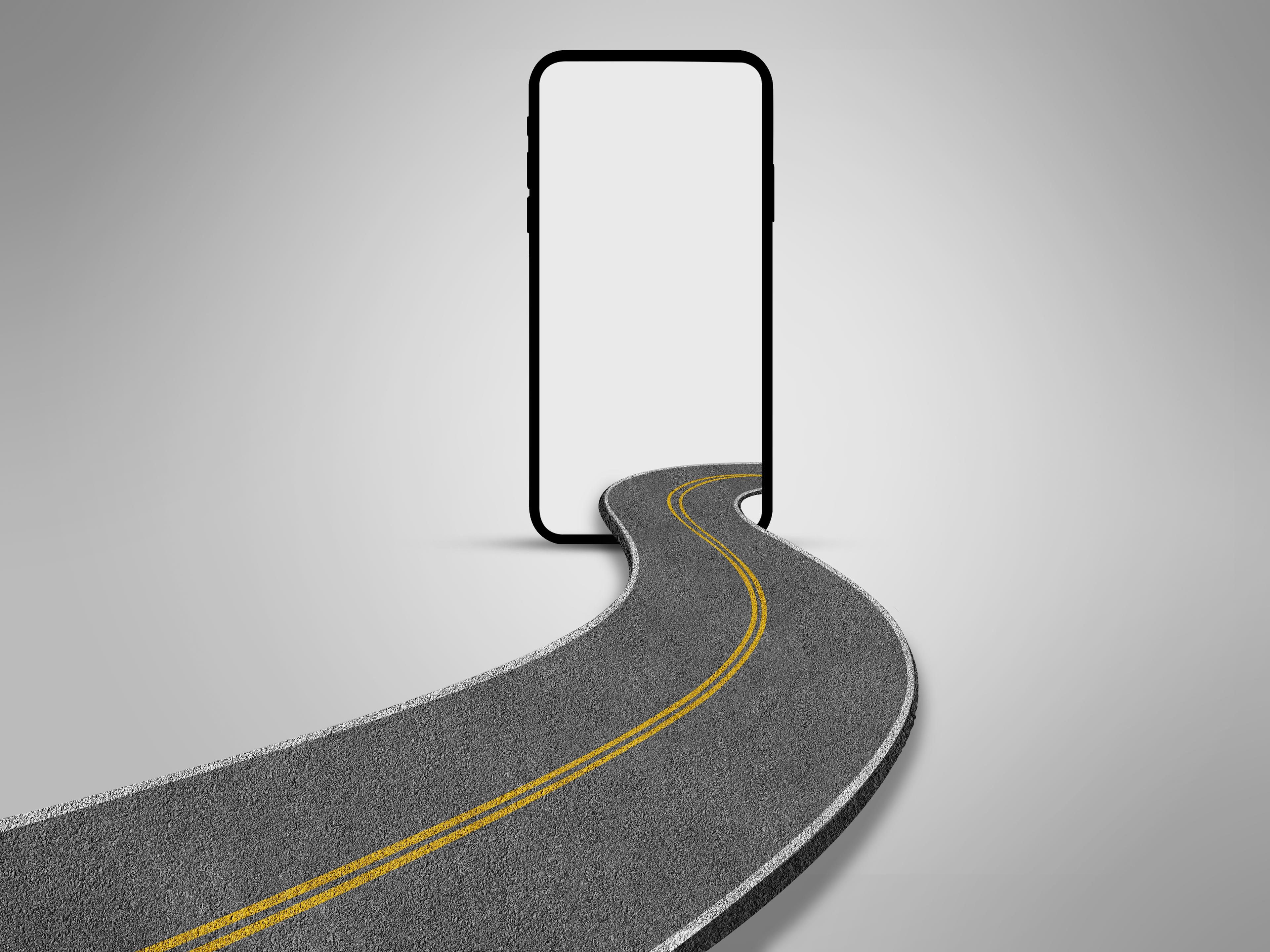A curved road with yellow lines leads into a blank smartphone screen against a gray background, creating a surreal visual concept