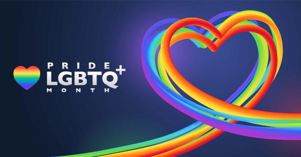 Stylized rainbow heart design with LGBTQ+ Pride Month text on dark background, featuring flowing multicolored ribbons